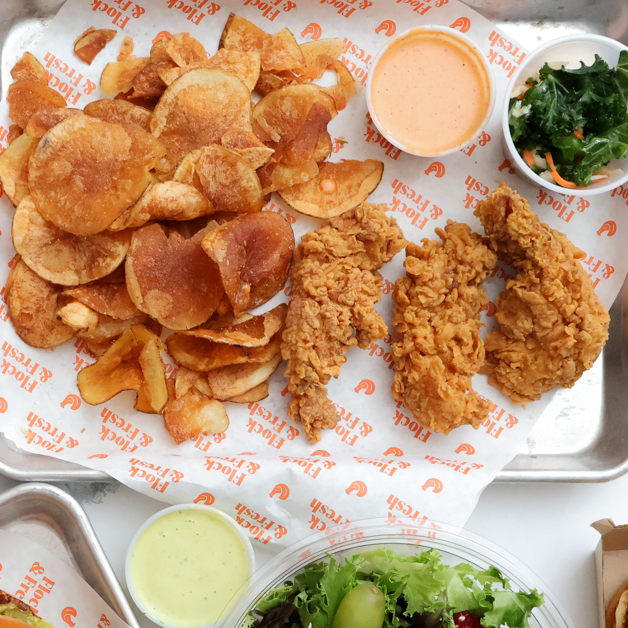 The Triple Flock — three crispy chicken tenders with house-made chips and kale salad at Flock & Fresh Dallas